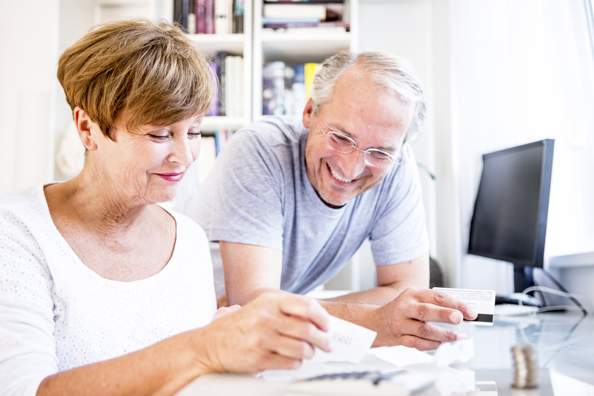 senior couple at desk paying bills